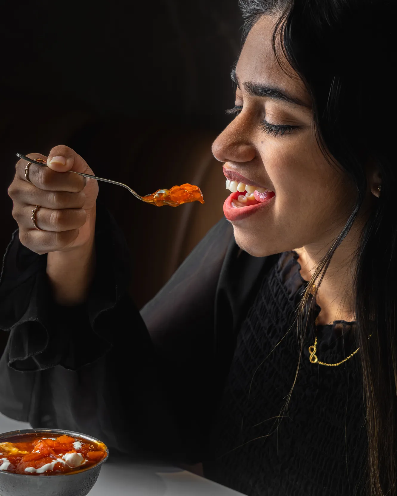 A guest smiling over a forkful of curry