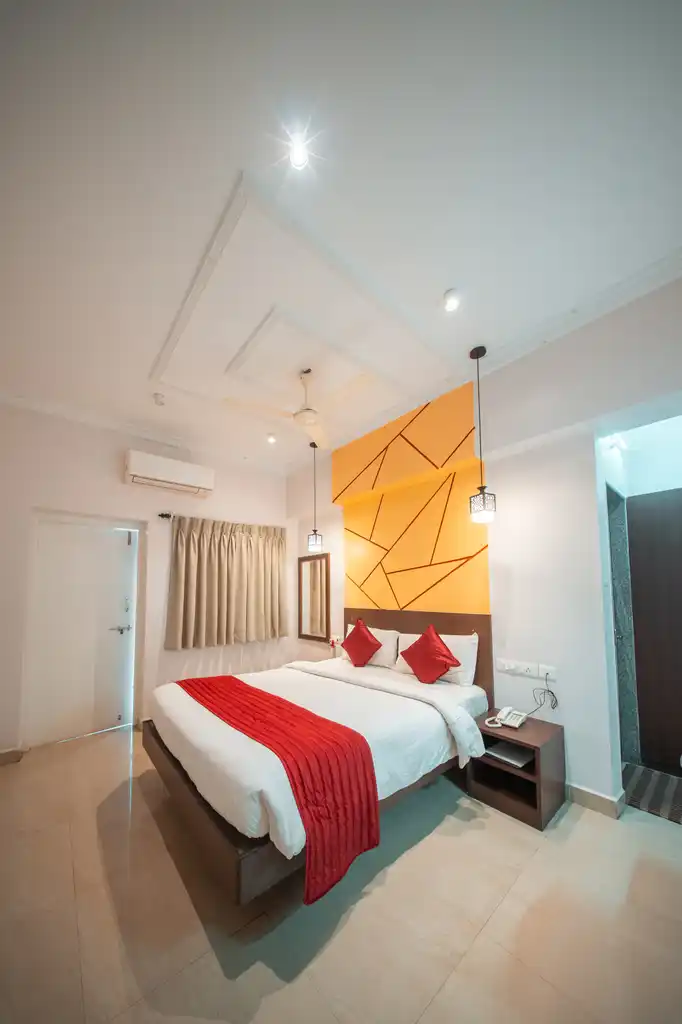 A Deluxe room, the queen bed set under a patterned gold headboard panel
