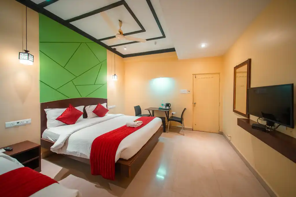 A Deluxe Twin room with two beds and a table by the window