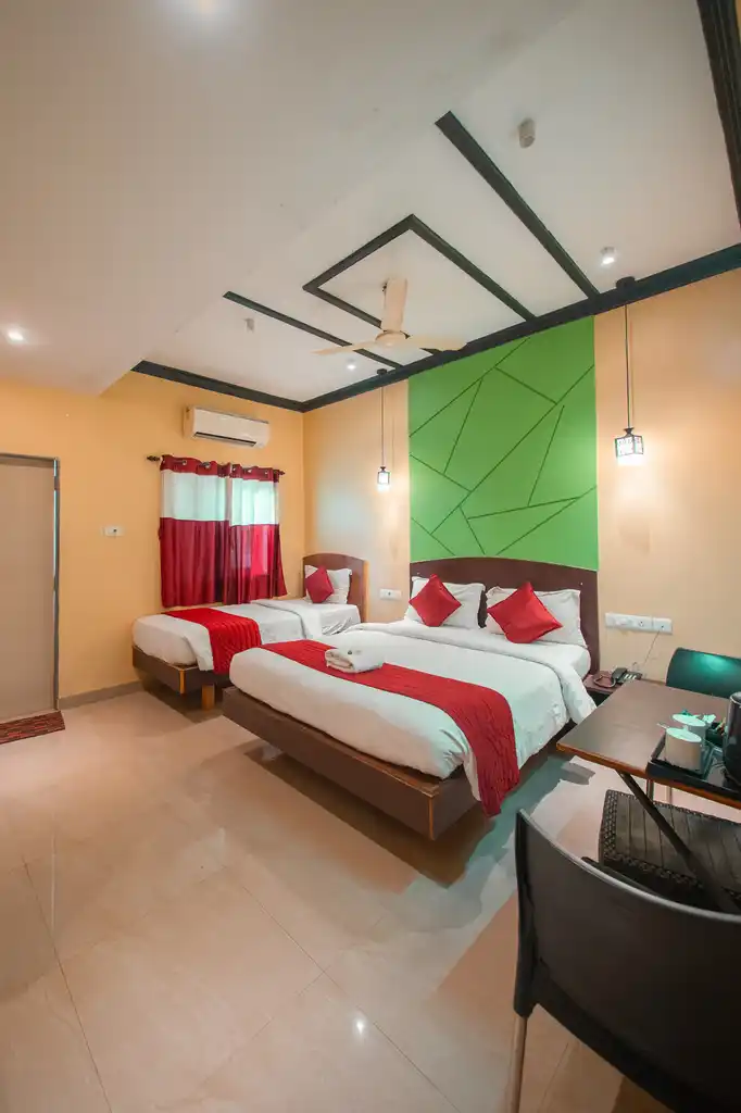 A Deluxe Twin room with two beds, television and curtained window