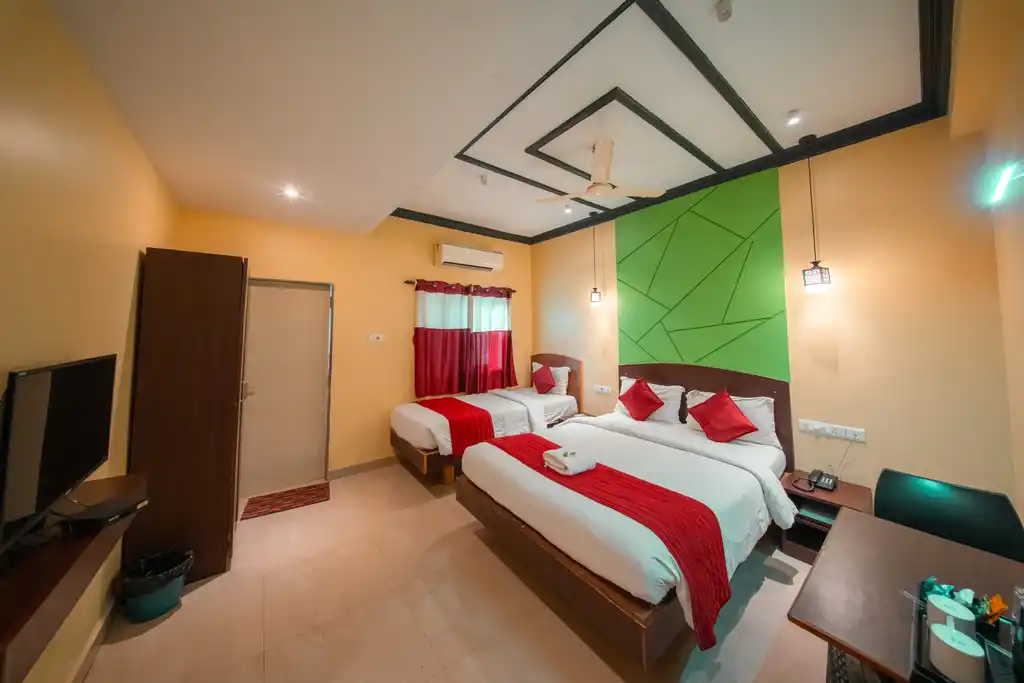 A Deluxe Twin room seen from the doorway, with three beds and a desk
